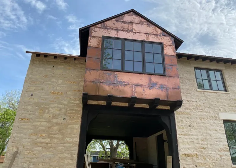 Copper metal panel facade on a stone building for Roof Repair in Oak Hill