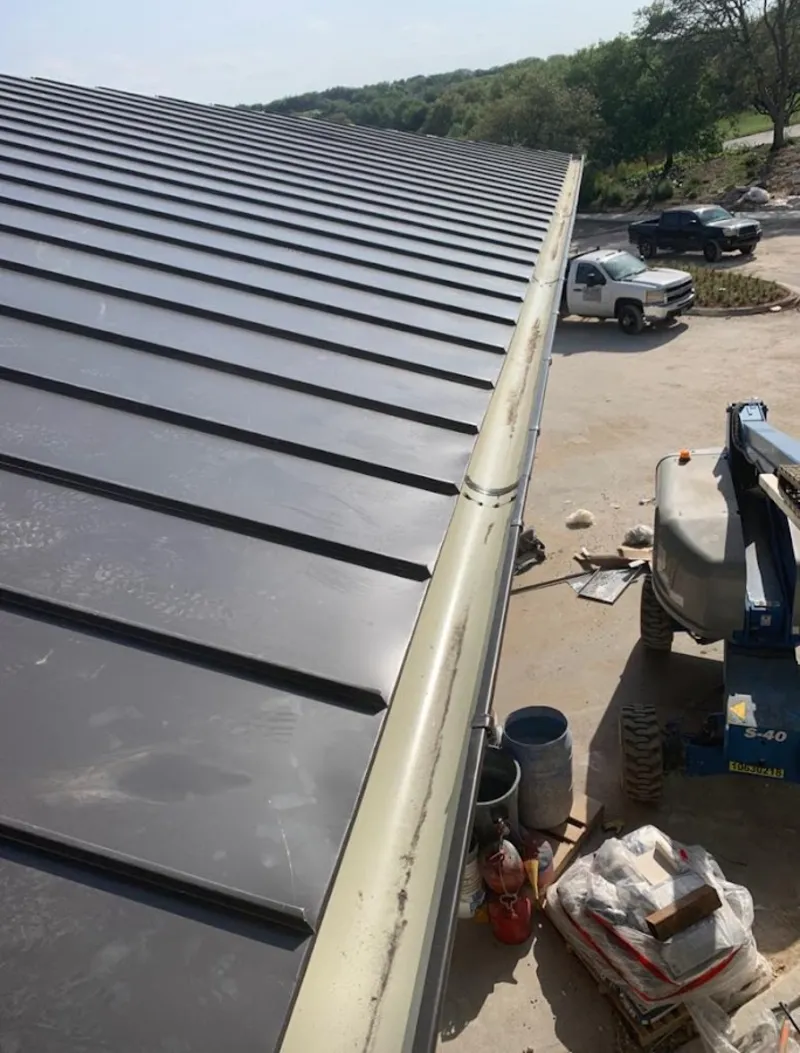 Standing seam panel and gutter detail on a metal roofing jobsite in Oak Hill